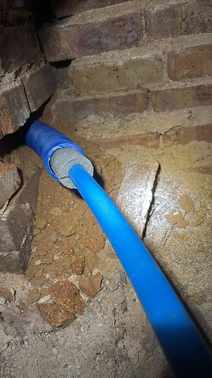 Blue water supply pipe protected within underground ducting