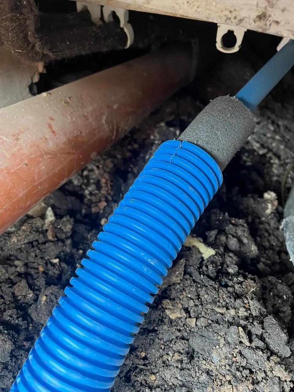 Blue water pipe protected at an underground entry point