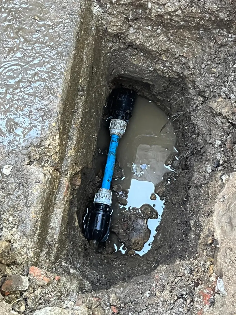 Modern blue water supply pipe connected below ground