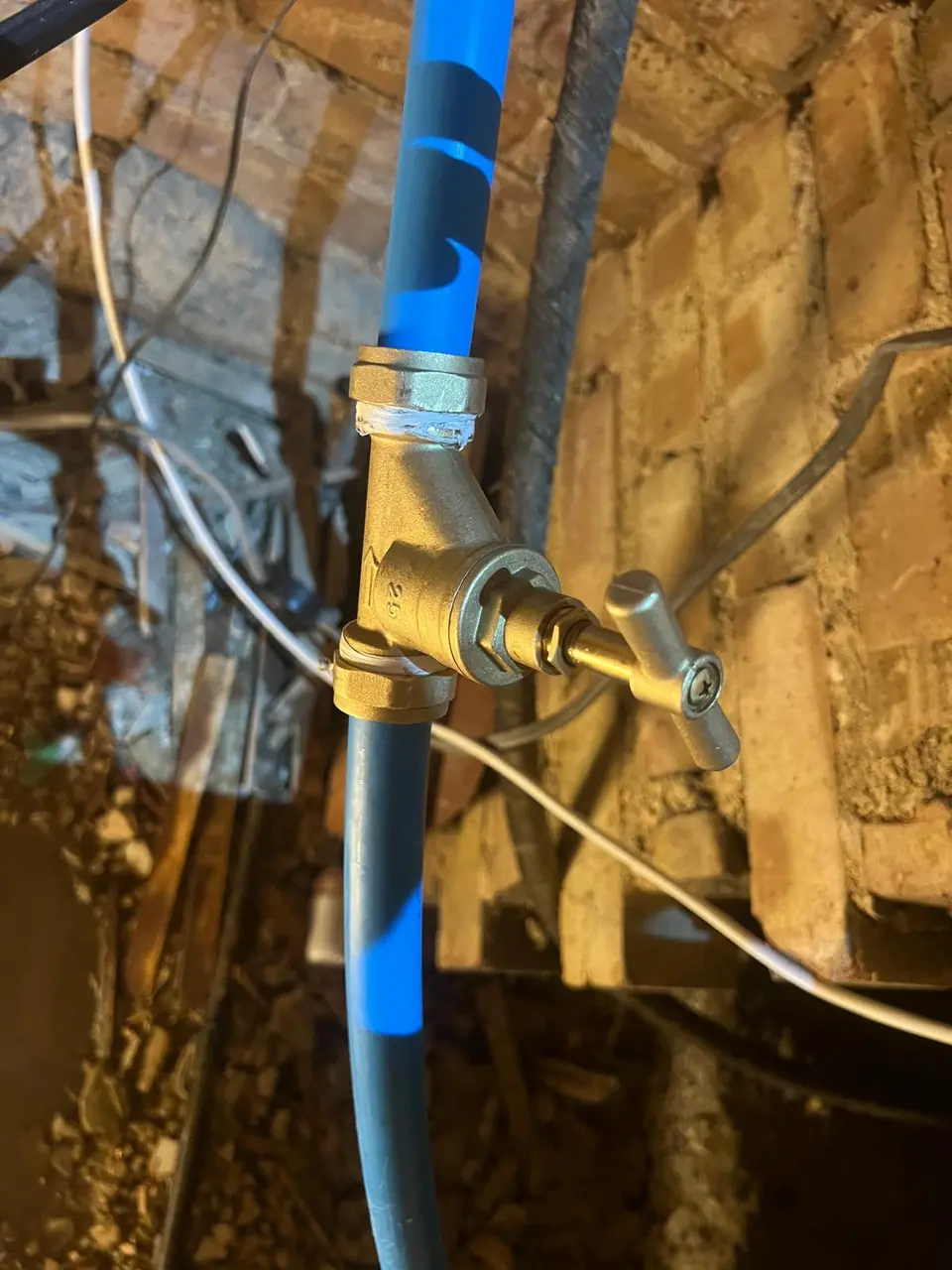 Brass stopcock connected to a new blue water supply
