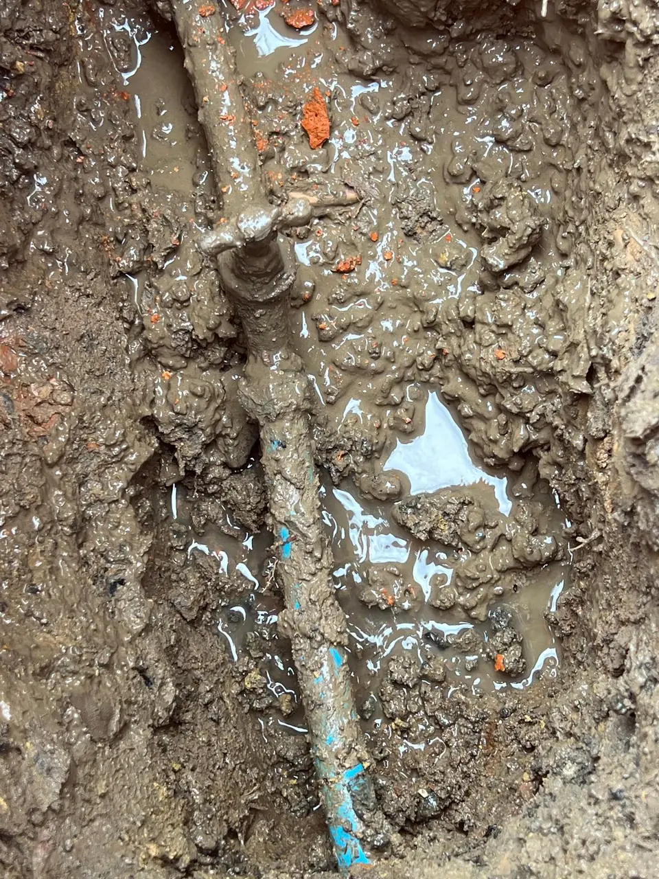 Old underground pipe fitting exposed for repair