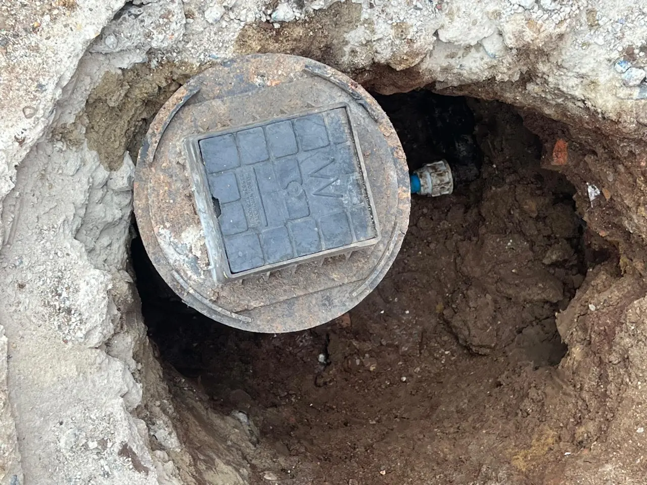 Underground water meter chamber exposed for repair