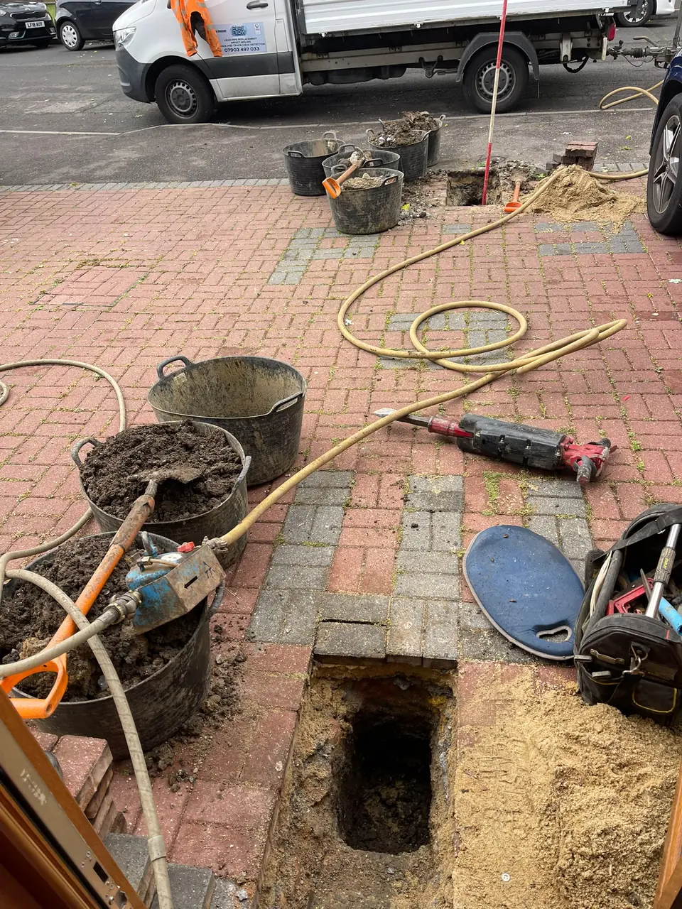 Underground pipe route being prepared on a block-paved driveway
