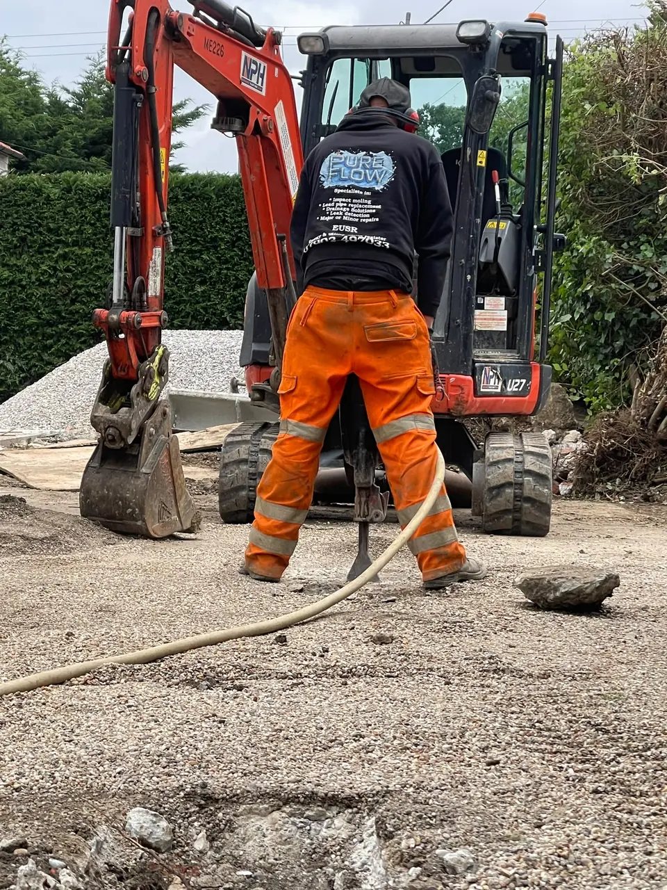 PureFlow specialist working with a mini digger on an underground pipe project