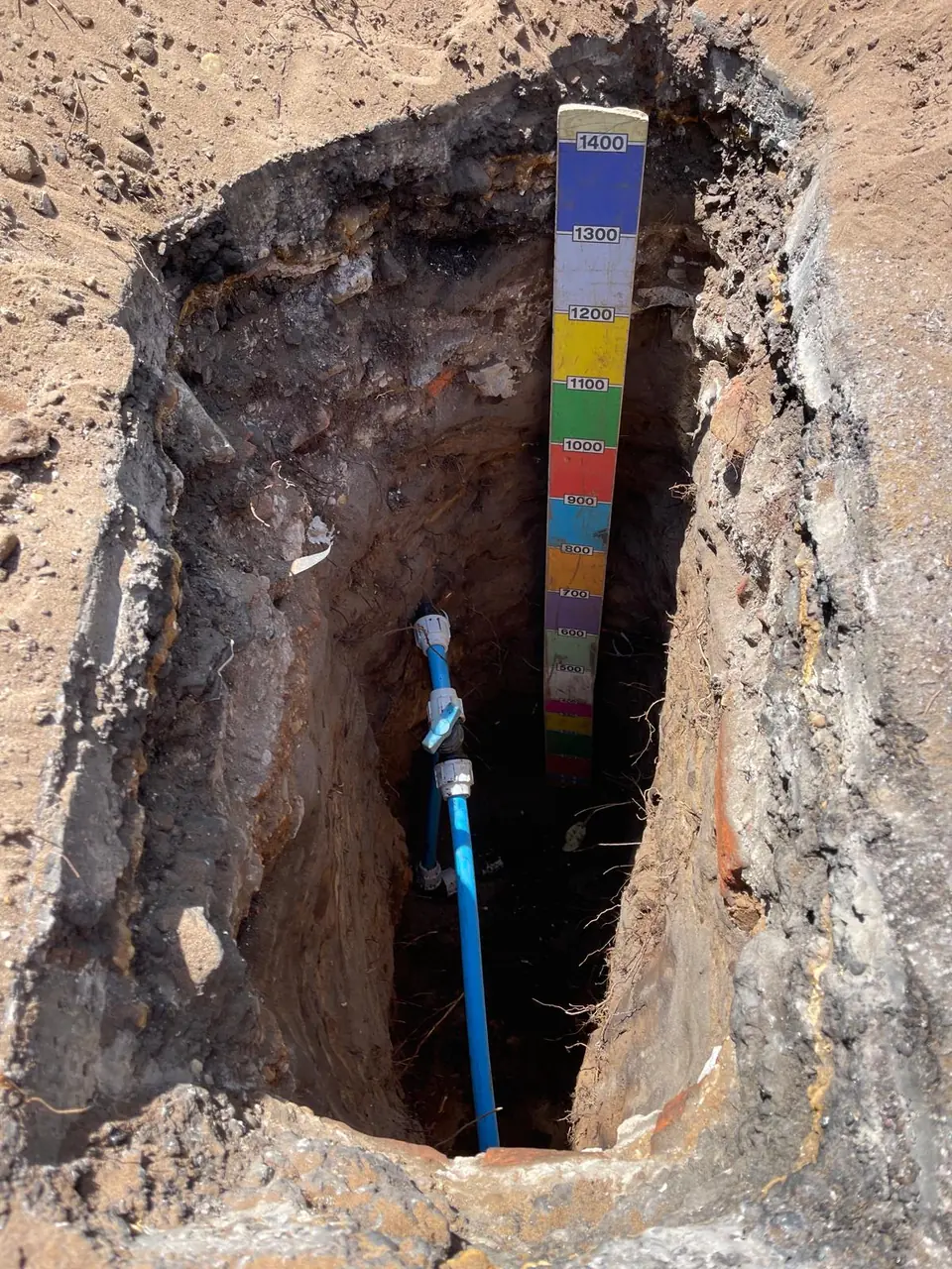 Depth being checked at an underground pipe access point