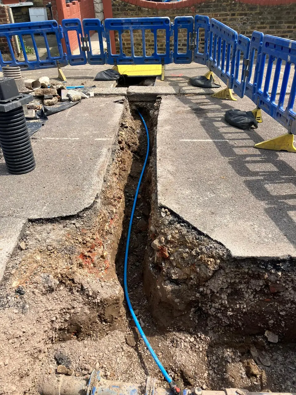New water supply installed in a narrow route beside a footway
